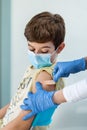 Nurse& x27;s hands with gloves put a band aid on a boy& x27;s arm after vaccination. Royalty Free Stock Photo