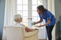 Nurse serving tea and biscuits to senior woman at home Royalty Free Stock Photo