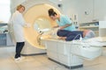 Nurse setting up scanning machine patient layed on