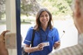 Nurse showing ID to senior man at his front door, close up Royalty Free Stock Photo