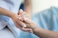 Nurse sitting on a hospital bed next to an older woman helping hands, care for the elderly concept Royalty Free Stock Photo