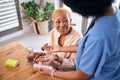 Nurse, smile and giving old woman pills in home with water for healthcare, wellness and support. Caregiver, medicine and Royalty Free Stock Photo