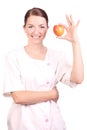 Nurse smiling and holding up an apple