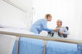 Nurse take care elderly woman isolated on wheelchair near bed in hospital room, concept of loneliness and old age diseases