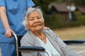 nurse take care and pushing happy senior woman in wheelchair at park Royalty Free Stock Photo