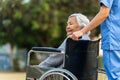 nurse take care and pushing happy senior woman in wheelchair at park Royalty Free Stock Photo