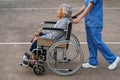 nurse take care and pushing senior woman in wheelchair at park, friendly caregiver Royalty Free Stock Photo