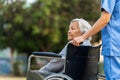 nurse take care and pushing stressed senior woman in wheelchair at park Royalty Free Stock Photo
