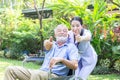 A nurse take care a senior male and thumb up on wheelchair in his garden at home Royalty Free Stock Photo
