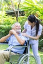 A nurse take care a senior male on wheelchair in his garden at home Royalty Free Stock Photo