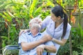 A nurse take care a senior male on wheelchair in his garden at home Royalty Free Stock Photo