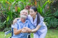 A nurse take care a senior male on wheelchair in his garden at home Royalty Free Stock Photo