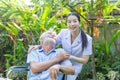 A nurse take care a senior male on wheelchair in his garden at home Royalty Free Stock Photo