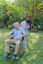 A nurse take care a senior male on wheelchair in his garden at home Royalty Free Stock Photo