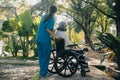 A nurse take care a senior male on wheelchair in his garden at home Royalty Free Stock Photo