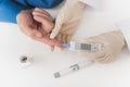 A nurse takes a blood sample with an old man`s scarifier. The nurse takes the blood to the glycemeter.