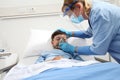 nurse puts oxygen mask on patient child in hospital bed, wearing protective visor mask, corona virus covid 19 protection concept, 