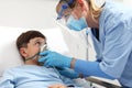 nurse puts oxygen mask on patient child in hospital bed, wearing protective visor mask, corona virus covid 19 protection concept, Royalty Free Stock Photo