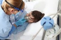 nurse puts oxygen mask on patient child in hospital bed, wearing protective visor mask, corona virus covid 19 protection concept, Royalty Free Stock Photo