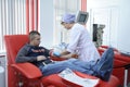 Nurse taking blood from the vain of the donor, hypodermic needle, tubes, container with blood