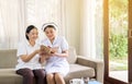 Nurse taking care reading a book to her patient mature asian elderly woman,Senior healthy concept Royalty Free Stock Photo