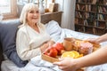Nurse taking care of senior woman breakfast retirement concept