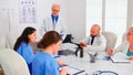 Nurse taking notes while elderly medical expert explaining viral diseases Royalty Free Stock Photo