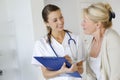 Nurse talking to elderly woman in hospital