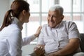 Nurse talks to old patient holds his hand showing kindness Royalty Free Stock Photo