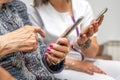 Nurse teaching elder woman how to use mobile phone, senior grandmother learning to use smartphone at nursing home