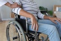 Nurse touch hand of elderly disabled woman in wheelchair closeup