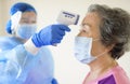 Nurse use an Infrared thermometer equipment to check the temperature on the forehead of senior woman