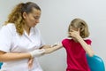 Nurse uses a syringe to vaccinate the child girl. Inoculation in the shoulder, in the hospital. Medicine, healthcare, pediatry and