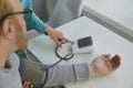 Nurse uses a tonometer to measure the blood pressure of a senior patient with hypertension Royalty Free Stock Photo