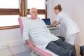 Nurse using laptop patient wearing gown and outdoor trousers Royalty Free Stock Photo