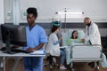 Nurse using personal computer to complete patient admission chart and read medical history