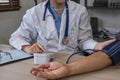 A nurse visits an elderly person for a health check. A young nurse measures the blood pressure of an elderly man at home Royalty Free Stock Photo