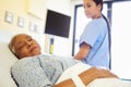 Nurse Watching Sleeping Senior Woman Patient In Hospital