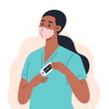 Nurse wearing a medical mask measures the oxygen level in the blood with a finger pulse oximeter