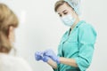 A nurse wearing a medical mask opens a disposable alcohol wipe