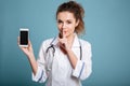 Nurse in white coat showing blank smartphone screen Royalty Free Stock Photo