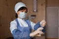 Nurse in a white mask in blue medical clothing stands holding a syringe in her hand. A female doctor is about to be vaccinated Royalty Free Stock Photo