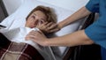 Nurse wiping tears of ill patient lying in sickbed, support and empathy concept