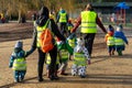 Nursery age children walking together with preschool teachers through a park wearing high visibility jackets Royalty Free Stock Photo