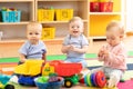 Nursery babies girl and boys playing together in a play room
