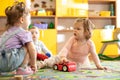 Nursery babies girls and boy playing together in a play room