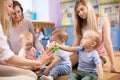 Nursery babies with parents play in playroom Royalty Free Stock Photo