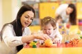 Nursery baby and teacher play with developmental toys in preschool Royalty Free Stock Photo