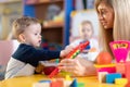 Nursery baby with kindergartener playing with abacus, early education