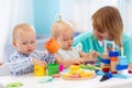 Nursery teacher and cute babies playing in creche